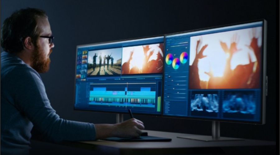 A monitor user in front of dual monitor setup using photo-editing software on the screen